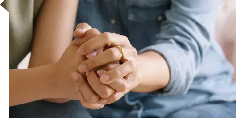 Zwei Personen stützen sich durch Händehalten